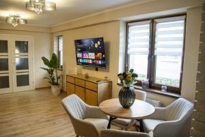 a living room with a table and chairs and a tv at U Marysi i Jerzego in Żarnowska