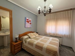 a bedroom with a bed and a sink and a chandelier at Casa Rural María Josefa in Bronchales