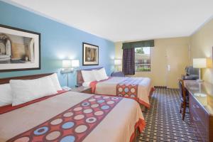 a hotel room with two beds and a television at Super 8 by Wyndham Jasper in Jasper