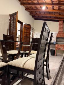 a group of chairs and tables in a room at Casa luzes Amarelas in Caraguatatuba