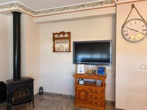 a living room with a television and a stove at Casa Rural María Josefa in Bronchales