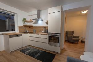 a kitchen with white cabinets and a stove at Ferienwohnung Bergsonne in Telfes im Stubai +10 photos