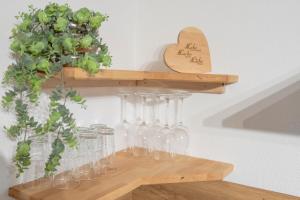 a bunch of wine glasses on a wooden shelf at Ferienwohnung Bergsonne in Telfes im Stubai