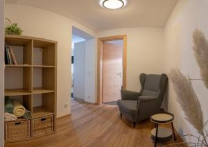 a living room with a chair and a book shelf at Ferienwohnung Bergsonne in Telfes im Stubai