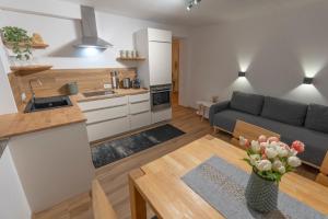 a kitchen and living room with a couch and a table at Ferienwohnung Bergsonne in Telfes im Stubai