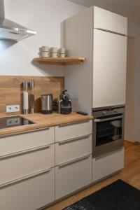 a kitchen with white cabinets and a stainless steel refrigerator at Ferienwohnung Bergsonne in Telfes im Stubai