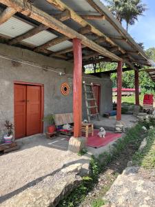 a patio with a wooden pergola with a dog under it at El hada de Yumbilla in Cuispes
