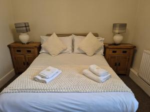 a bed with two towels on it with two lamps at The Royal Oak Pub in Lampeter