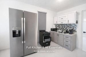 a kitchen with a refrigerator and a stove at Modern Private Stay in Fajardo, PR - NEAR FERRY - BEACHES - EL YUNQUE - BIO BAY in Fajardo