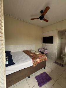 a bedroom with a bed and a ceiling fan at HOTEL TÊTÊ in Várzea Grande