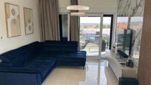 a living room with a blue couch and a large window at Luxury with jacuzzy on a private roof terrace in Nin