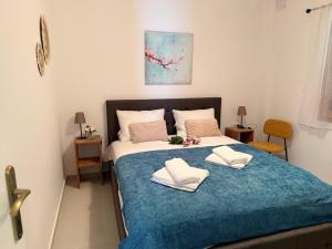 a bedroom with a large bed with two towels on it at NIVAS Apartment Pefkochori in Pefkochori