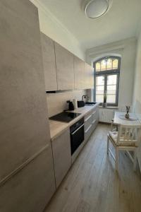 a kitchen with white cabinets and a table with a chair at Ferienwohnung Muranko in Bad Doberan