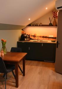 a kitchen and dining room with a table and a sink at Cetti's Lodge - met privé sauna in Nieuwkoop