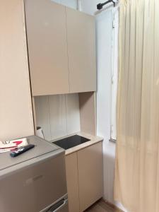 a small kitchen with white cabinets and a window at MN apartment in Yerevan in Yerevan +1 photo