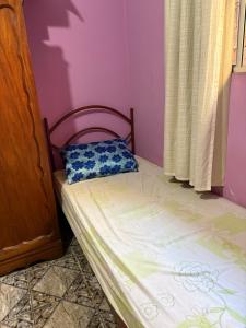 a small bedroom with a bed with a pillow on it at Quarto com duas camas confortáveis in Belo Horizonte