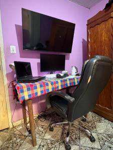 a desk with a laptop and a computer on it at Quarto com duas camas confortáveis in Belo Horizonte