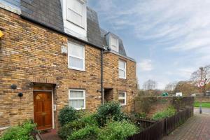 a brick house with a brown door and a fence at Flat in Lambeth in London