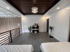 a room with two beds and a balcony with a lamp at The Guest House Zambales in Cabangan