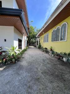 a yellow and white building with plants next to it at The Guest House Zambales in Cabangan