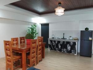 a kitchen with a table and chairs and a refrigerator at The Guest House Zambales in Cabangan