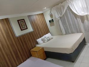 a small bedroom with a bed and a window at 3 bedroom self catering in Rustenburg