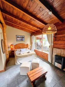 a bedroom with a bed in a room with a fireplace at Cabañas Walnor in Villa Traful