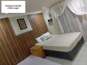a small bedroom with a bed with a window at 3 bedroom self catering in Rustenburg +7 photos
