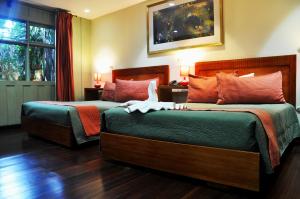 a hotel room with two beds and a window at Hotel Aranjuez in San José