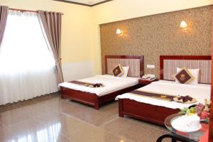a hotel room with two beds and a table at Tran Vinh Hotel in Bạc Liêu +35 photos