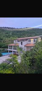 a large white house on top of a hill at Qyteza guest house in Shkodër
