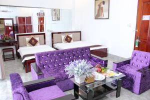 a living room with two purple chairs and a table at Tran Vinh Hotel in Bạc Liêu