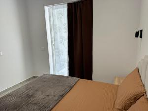 a bedroom with a bed and a window with curtains at Qyteza guest house in Shkodër