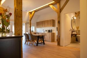 a kitchen and dining room with wooden beams at Relax In A Thatched Barn With A Sauna in Ratekau