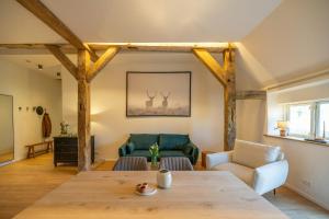 a living room with a table and a couch at Relax In A Thatched Barn With A Sauna in Ratekau