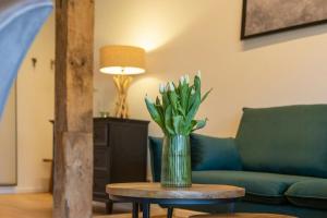 a vase of flowers on a table in a living room at Relax In A Thatched Barn With A Sauna in Ratekau +12 photos