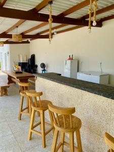 a kitchen with wooden stools and a counter top at Chácara Jacinto Alves in Paulo Afonso