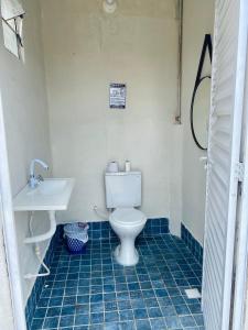 a bathroom with a toilet and a sink at Chácara Jacinto Alves in Paulo Afonso