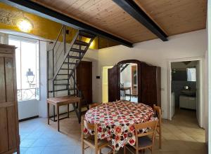 a dining room with a table and a staircase at Appartamento vacanze Loano in Loano
