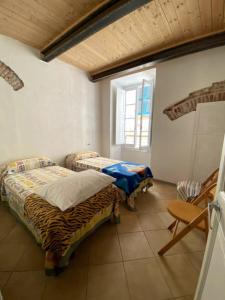 two beds in a room with a window at Appartamento vacanze Loano in Loano