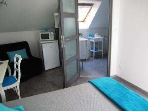 a room with a bed and a microwave and a table at La Renaissance Saint-Gervais-la-Forêt in Saint-Gervais-la-Forêt