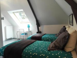 a bedroom with two beds and a window at La Renaissance Saint-Gervais-la-Forêt in Saint-Gervais-la-Forêt