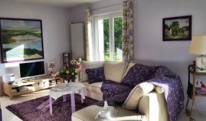 a living room with a couch and a tv at La Renaissance Saint-Gervais-la-Forêt in Saint-Gervais-la-Forêt