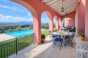 a patio with a table and chairs and a pool at Villa Olea Corfu - Private Pool & Panoramic Views in Perama