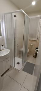 a white bathroom with a shower and a sink at Volta B&B Imola in Imola +14 photos