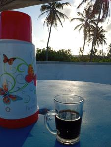 a cup of coffee sitting next to a thermos at POUSADA GOLFINHO FLECHEIRAS Ce in Trairi