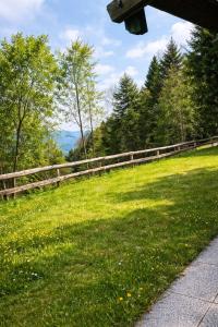 a wooden fence in a field with grass and trees at Ferienhaus am Reisberg in Reisberg