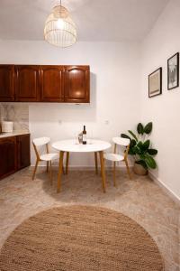 a dining room with a white table and chairs at Olive tree Apartment Kanoni in Kanoni