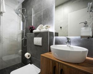 a bathroom with a white sink and a shower at Boutique Hotel Una in Sarajevo +22 photos