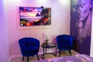 a room with two blue chairs and a table at Foča Apartman STORY LUX in Foča